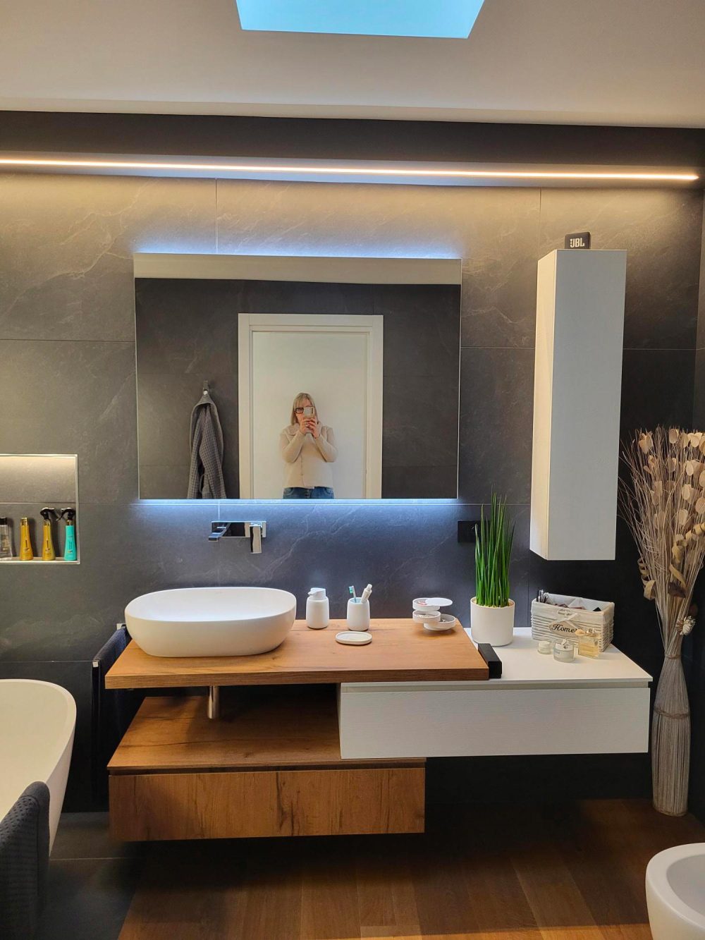 Dettaglio dei materiali del bagno equilibrio tra tonalità calde del legno e colori scuri nella casa