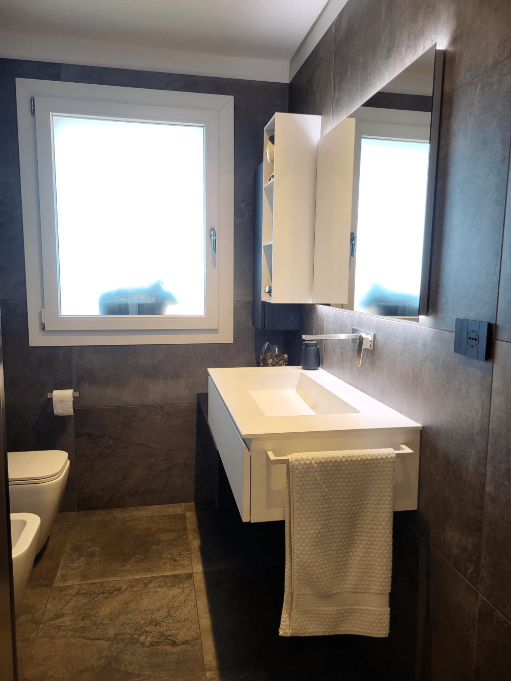 Dettaglio dei materiali del bagno equilibrio tra tonalità calde del legno e colori scuri nella casa