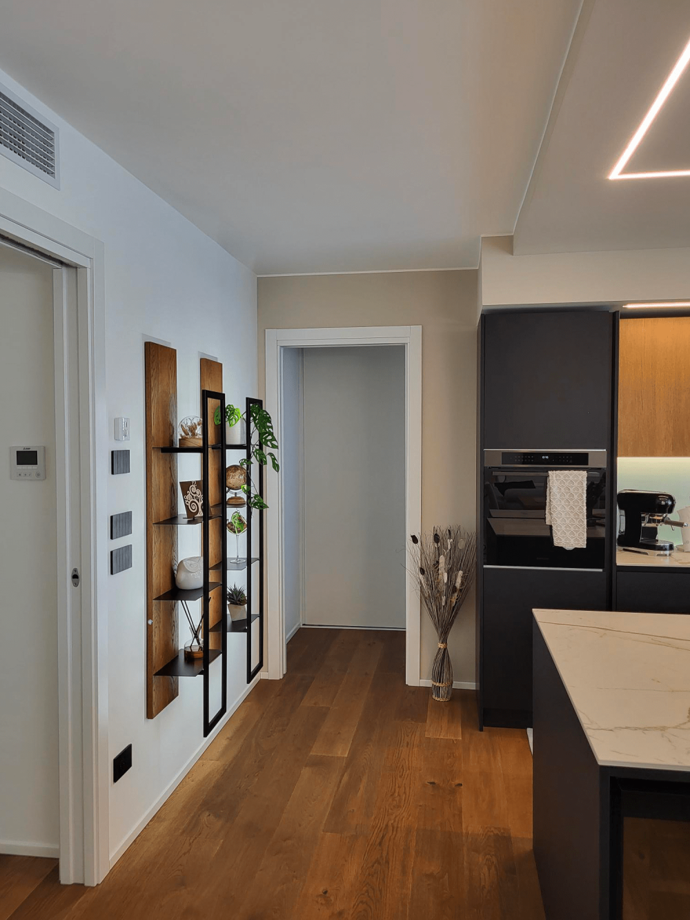 Dettaglio dei materiali ingresso zona giorno equilibrio tra tonalità calde del legno e colori scuri nella casa