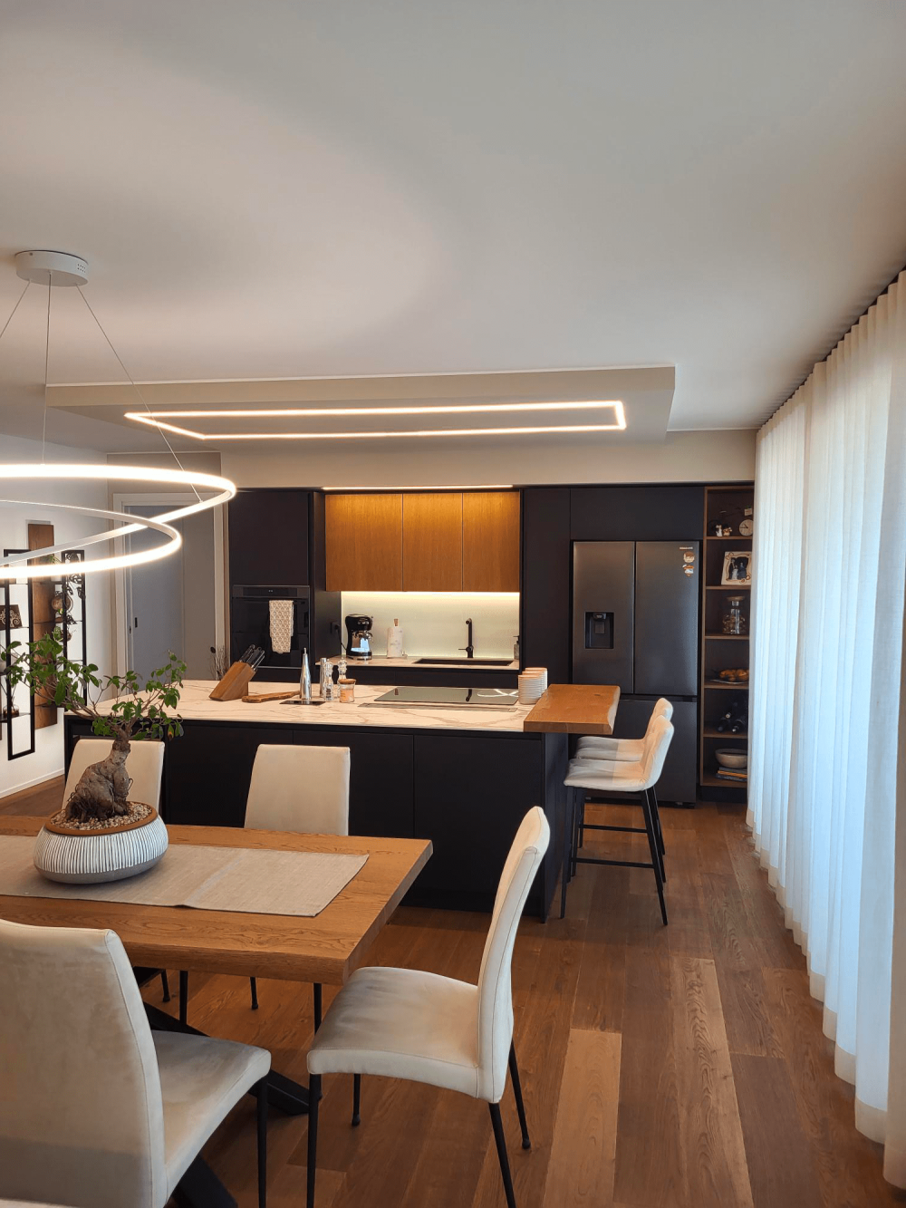 Dettaglio dei materiali cucina e sala zona giorno equilibrio tra tonalità calde del legno e colori scuri nella casa