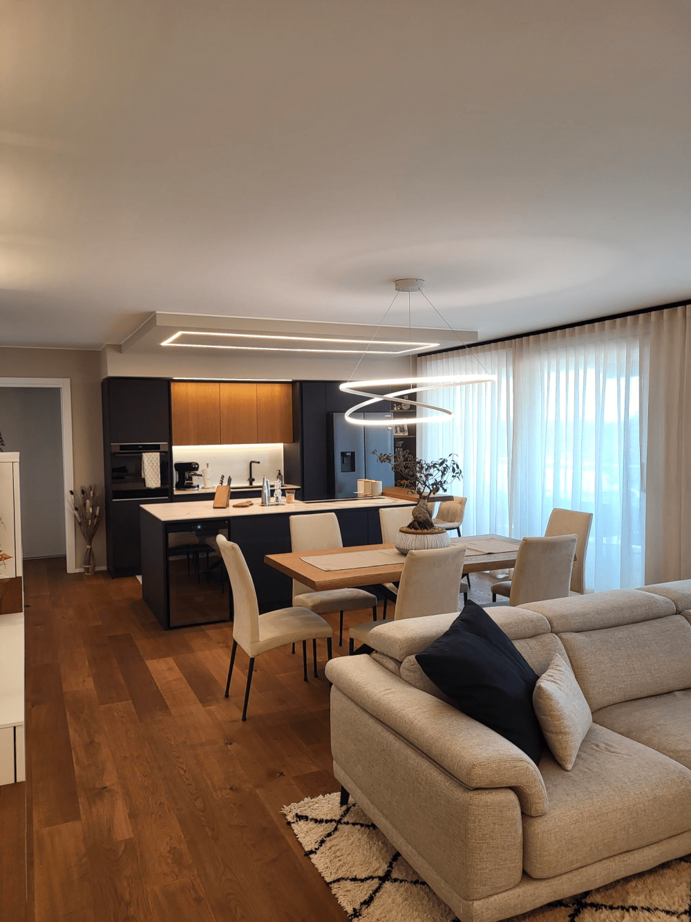 Dettaglio dei materiali cucina e sala zona giorno equilibrio tra tonalità calde del legno e colori scuri nella casa